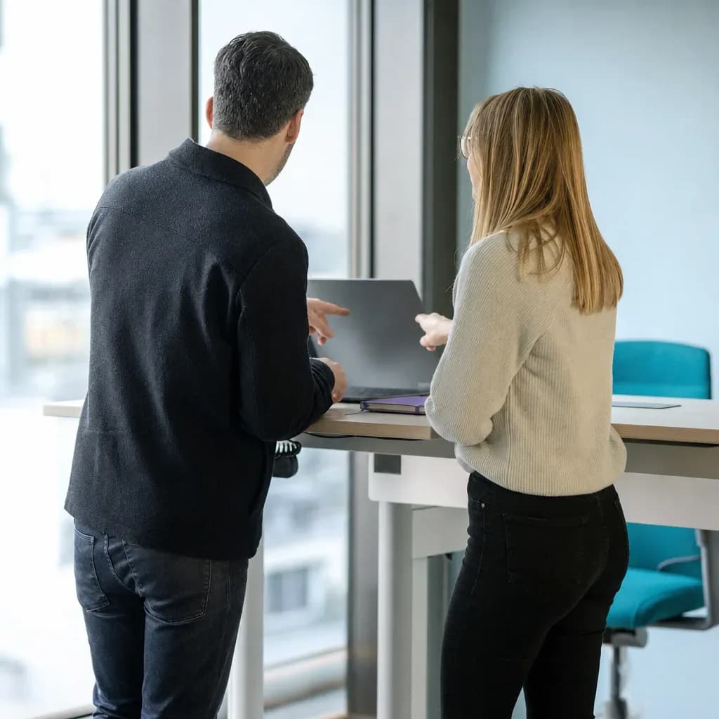 Zwei Personen am Stehtisch richten eine Kampagne für ChatGPT Ads ein